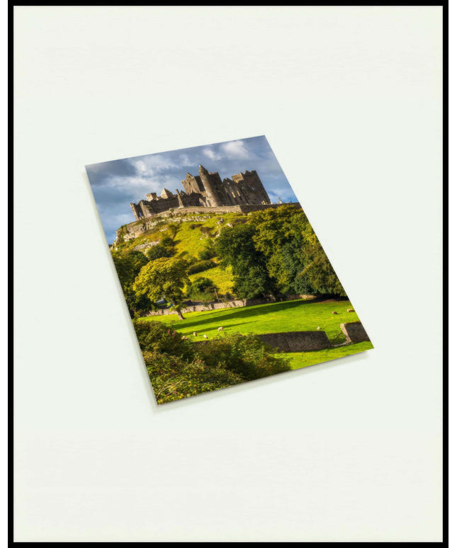 Eine Postkarte von den Ruinen des Rock of Cashel auf einem Hügel in Irland, umgeben von grünen Wiesen und Bäumen.