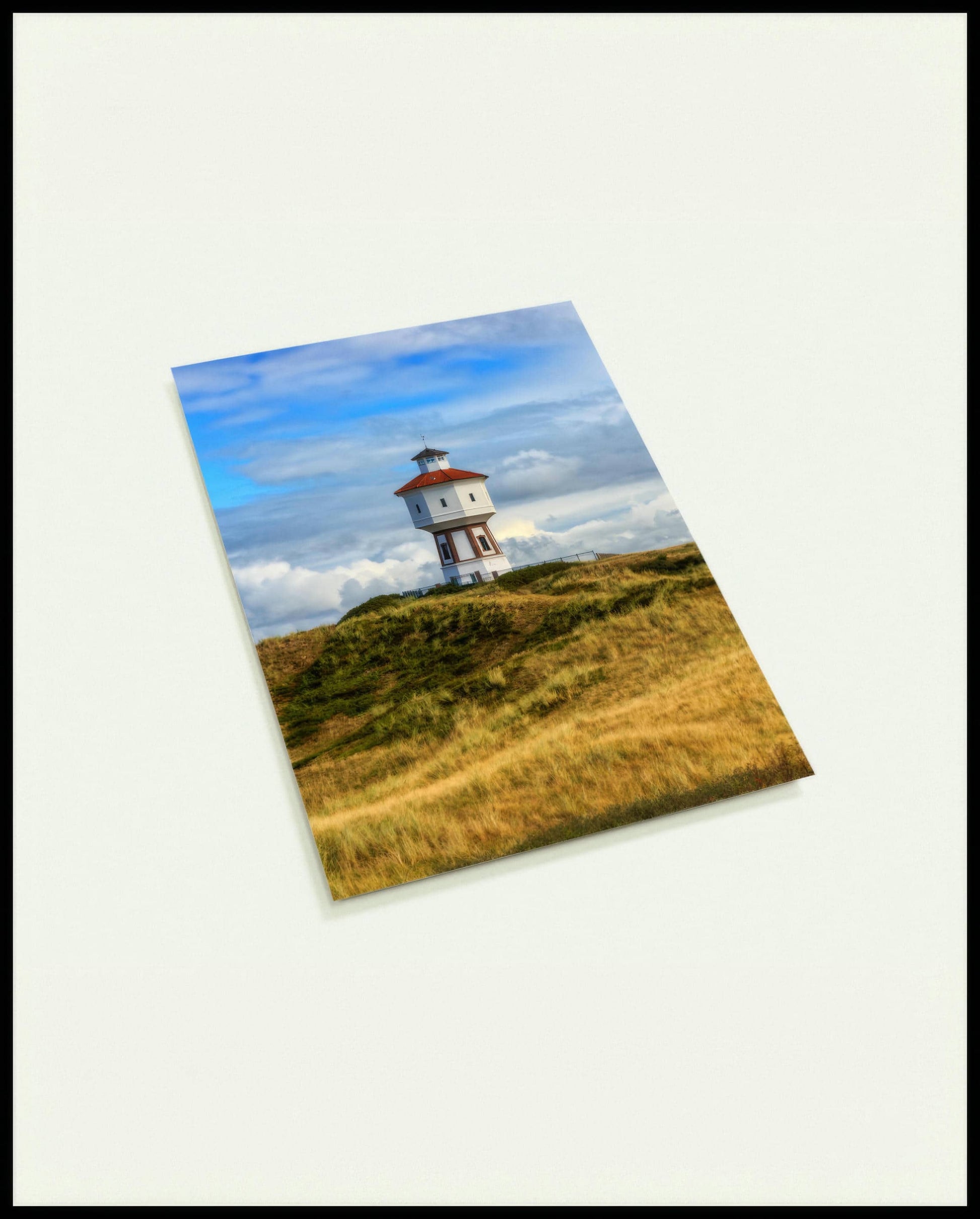 Eine Postkarte von einem weißen Wasserturm auf der Insel Langeoog.