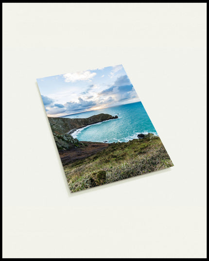 Eine Postkarte vom Blick einer Bucht über das blaue Meer.