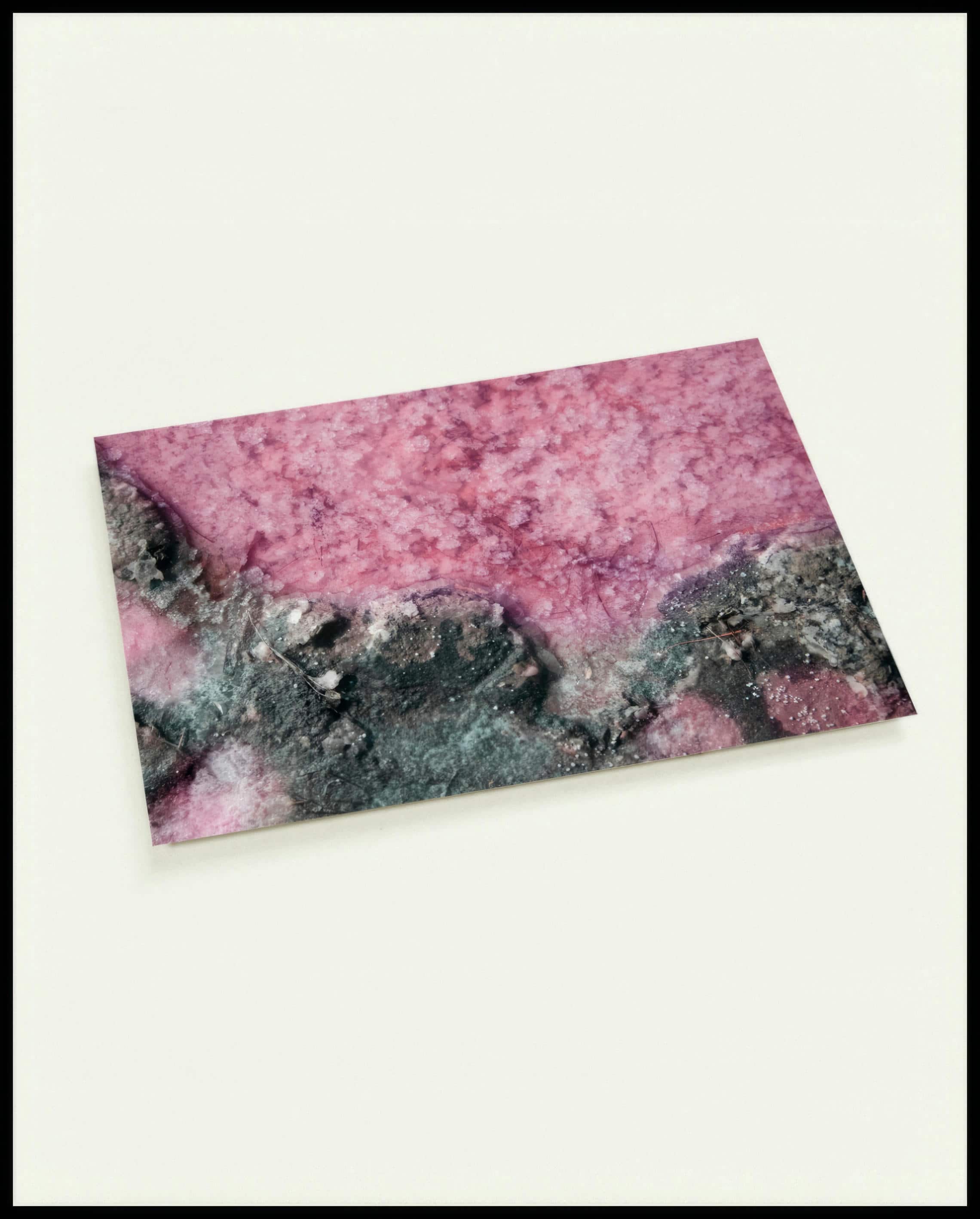 Eine Postkarte von rosa Salz und dunklem Gestein.
