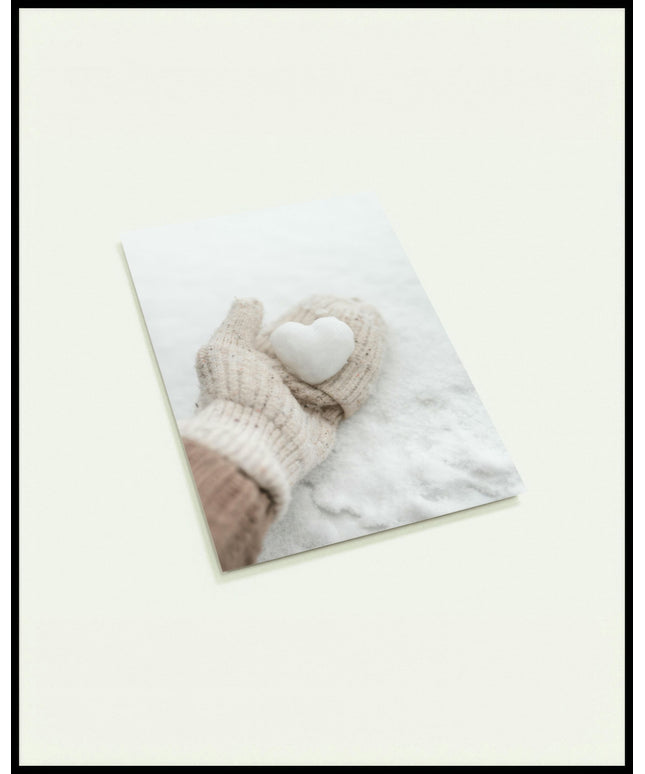 Eine Postkarte von einer behandschuhten Hand, die ein kleines Herz aus Schnee hält.