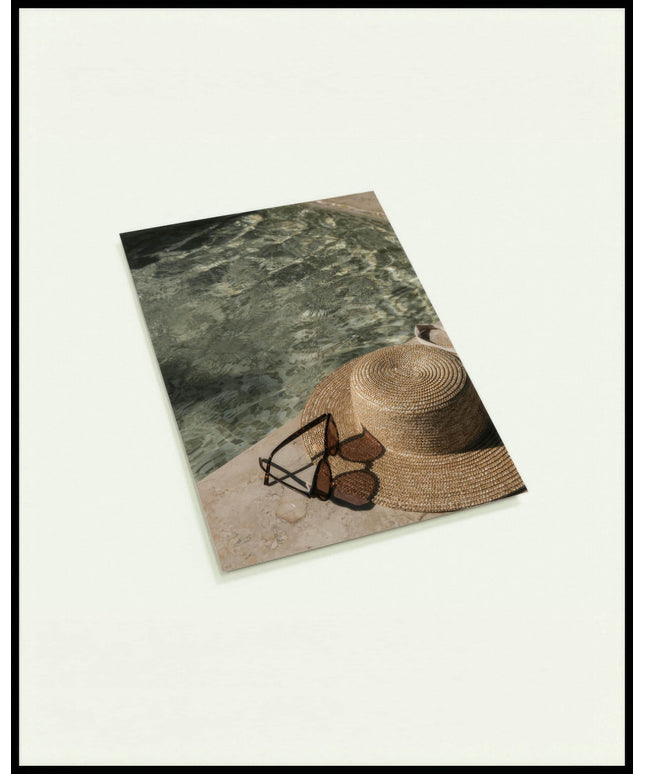 Eine Postkarte von einem Sonnenhut und einer Sonnenbrille neben einem Swimming Pool aus Marmor.