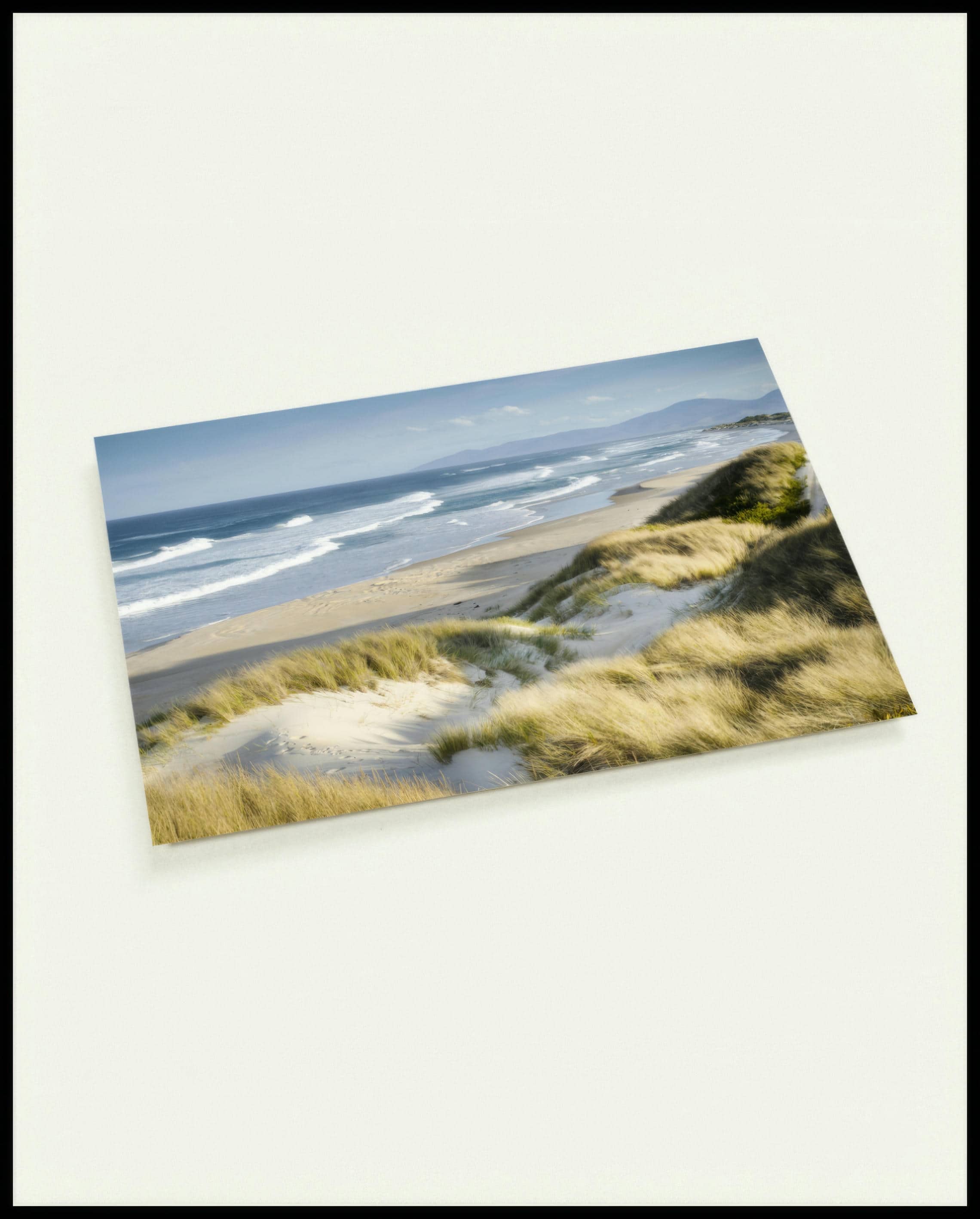 Eine Postkarte vom Meerblick über Dünen und Strand.