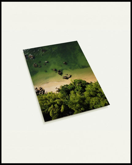 Eine Postkarte von einem Sandstrand mit grünlichem Wasser vor einem tropischen Wald.